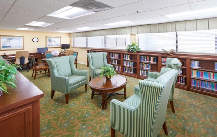 A cozy library seating area with armchairs and bookshelves.