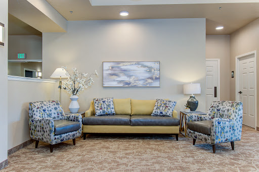 A stylish living room featuring a modern sofa and patterned chairs, illuminated by soft lighting.