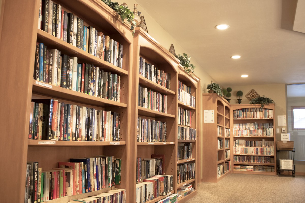 A cozy library with rows of books neatly arranged on wooden shelves.