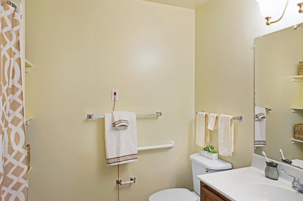 A simple bathroom with a toilet, sink, and neatly hung towels.