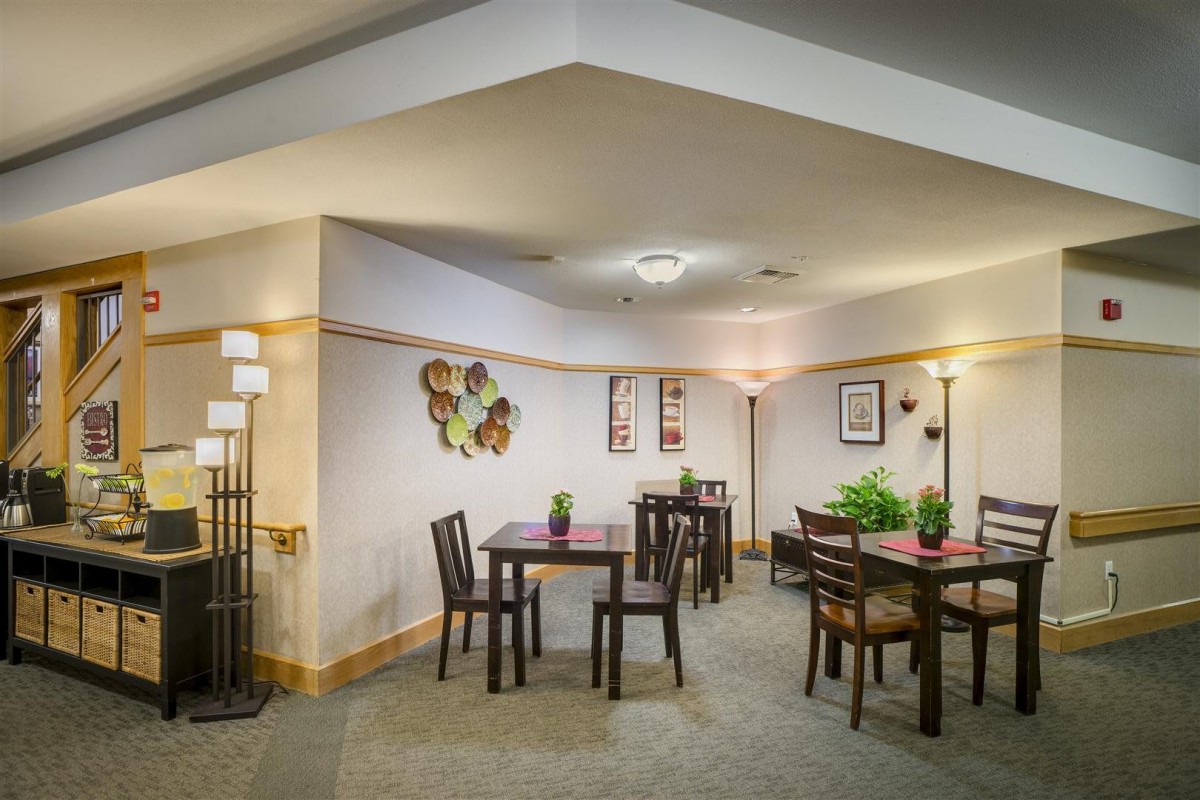 A cozy indoor dining area with neatly arranged tables, chairs, and decorative elements.
