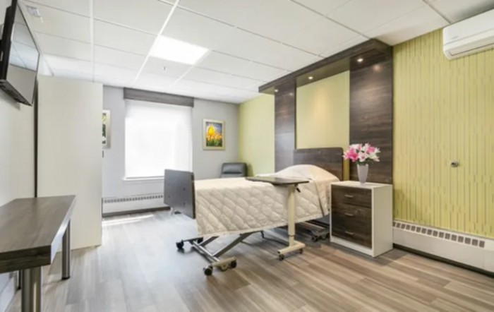 A modern hospital room with a bed and minimalist decor.