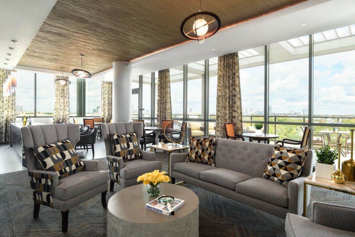A modern lounge area with comfortable seating and large windows letting in natural light.