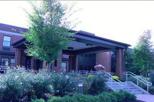 A modern building surrounded by lush greenery and a well-maintained garden.