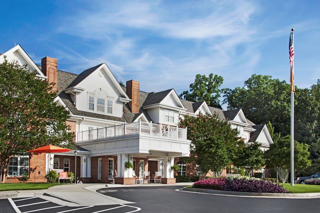 A large residential building with landscaped surroundings on a sunny day.