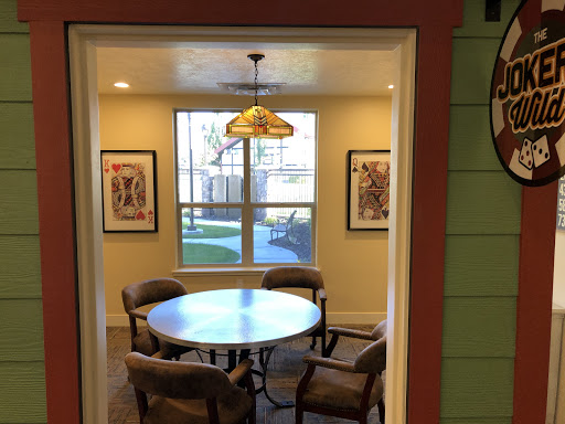 A cozy dining area with a round table and comfortable chairs, illuminated by a stylish pendant light.