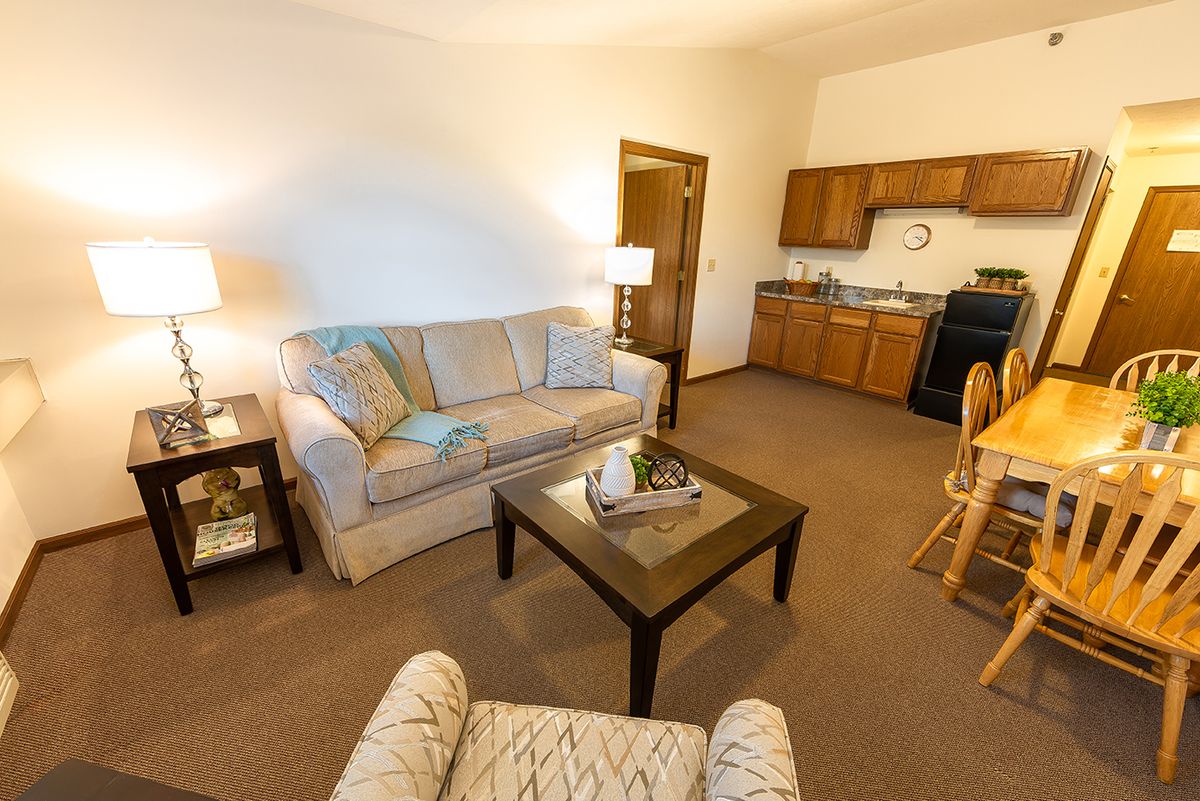 A cozy living room with a sofa, coffee table, and adjacent kitchen area.