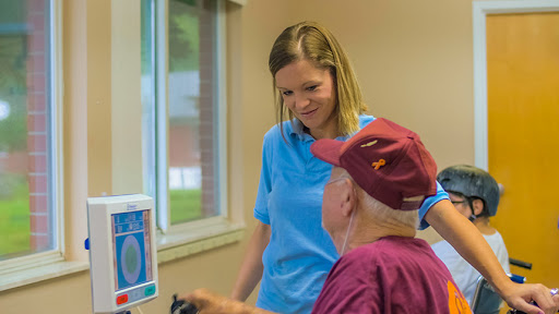 A healthcare professional engages with an elderly patient in a supportive and friendly environment.