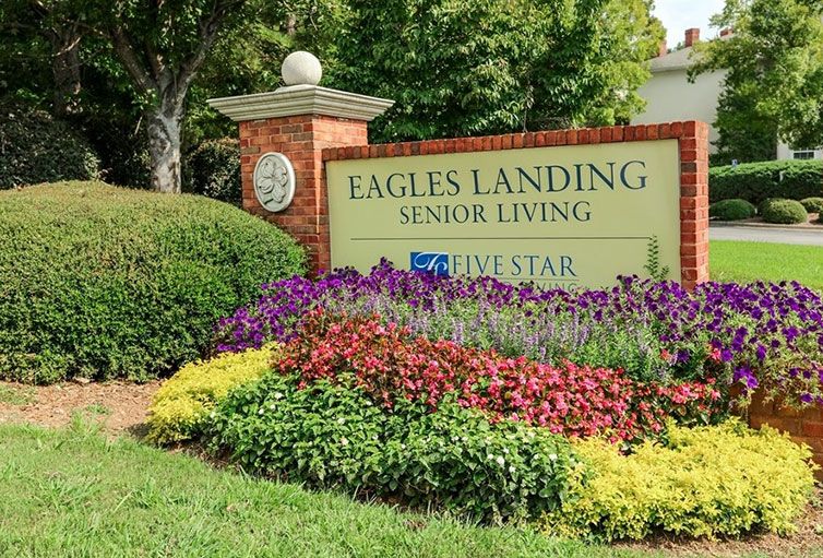 Eagles Landing Senior Living entrance with vibrant flower garden.
