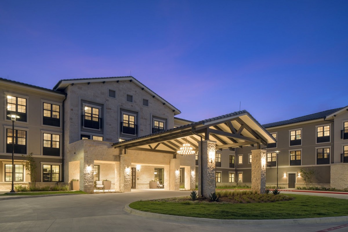 A modern building with a well-lit entrance at night.