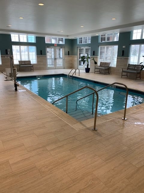 An indoor swimming pool with a seating area for relaxation.