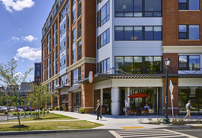 A modern mixed-use building with retail space on the ground floor and residential apartments above.