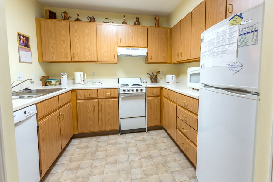 A cozy kitchen with wooden cabinets and essential appliances.