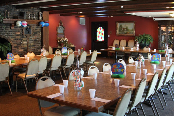 A spacious dining area with neatly arranged tables and chairs, prepared for an event.