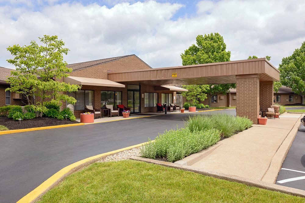 A building with a covered entrance and landscaped surroundings.