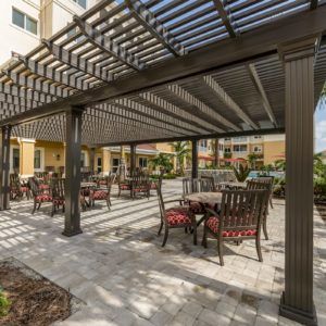 An inviting outdoor patio area with tables and chairs under a pergola.