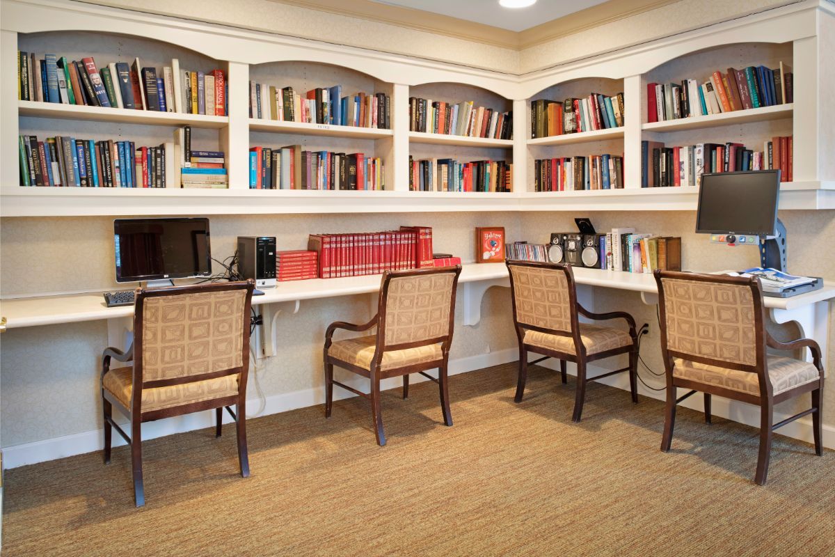 A cozy library with bookshelves, desks, and chairs for reading or study.