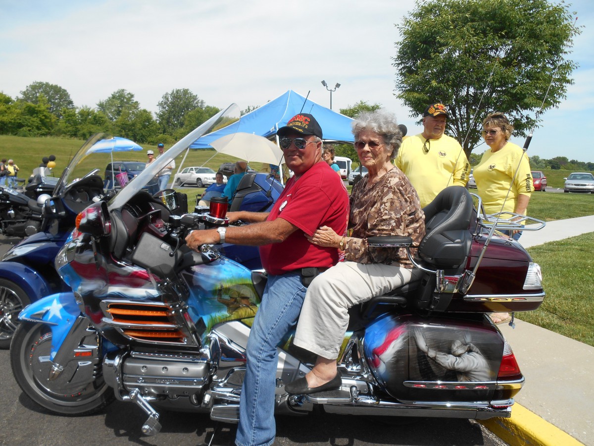 A couple enjoys a motorcycle ride at an outdoor event.