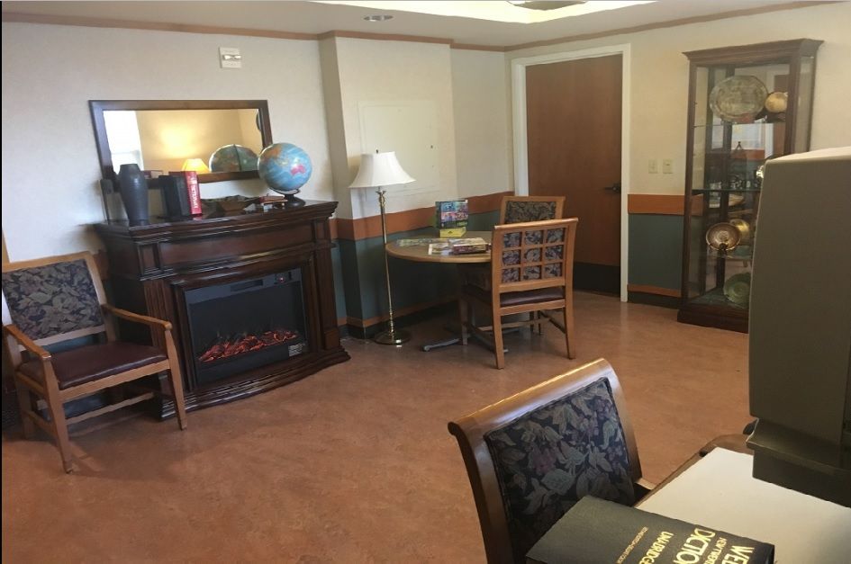 A cozy office space with a fireplace, globe, and wooden furniture.