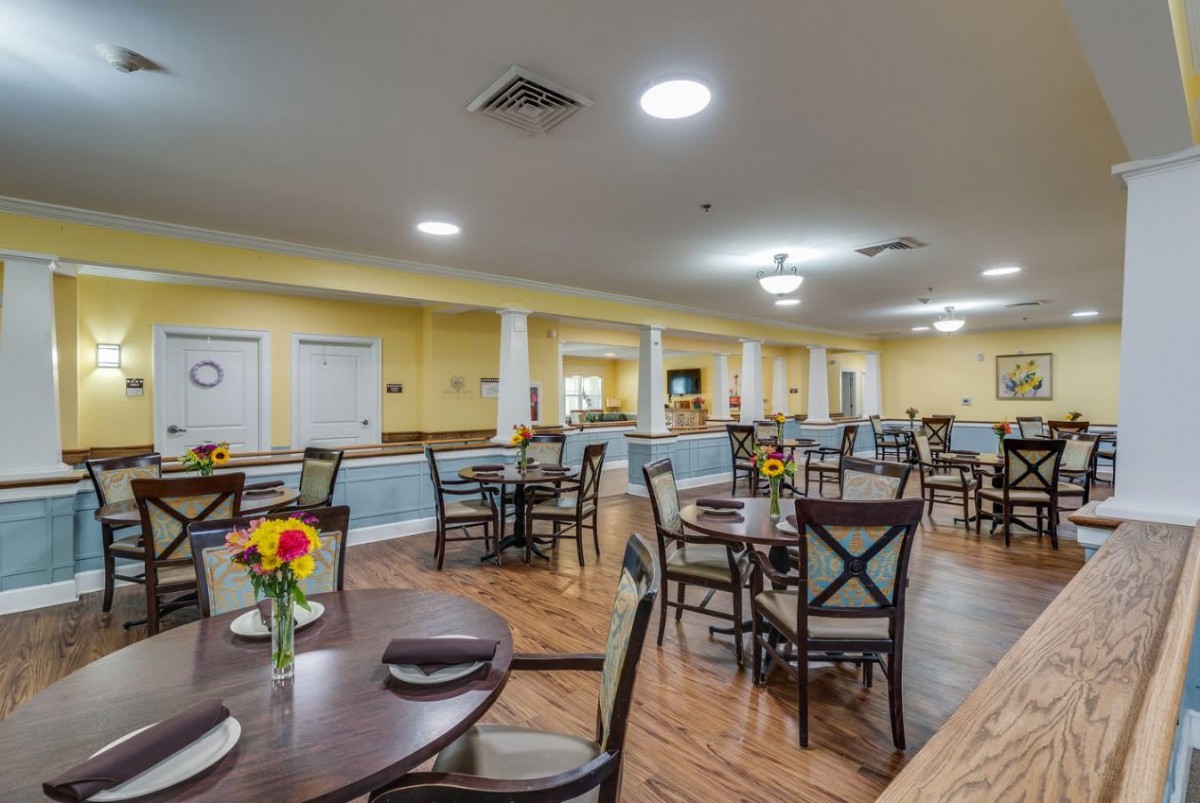 A spacious dining area with neatly arranged tables and chairs, featuring a warm and inviting atmosphere.