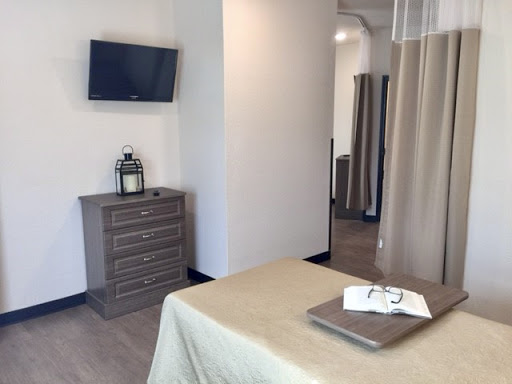 A serene and modern treatment room in a spa, featuring calming decor and essential amenities.