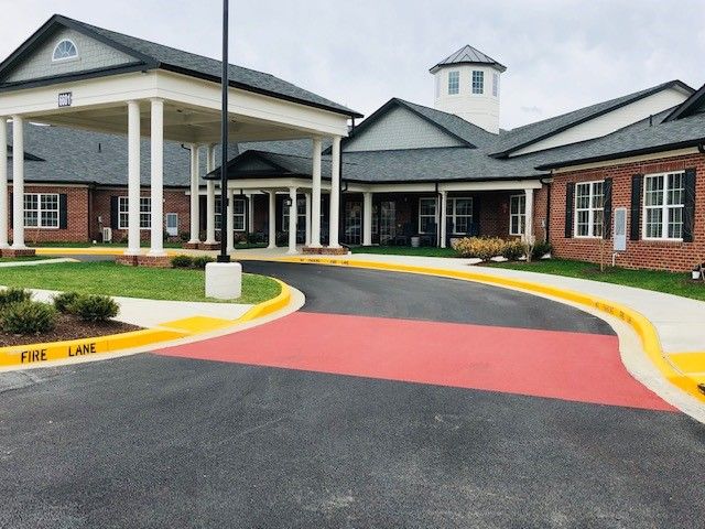 A modern building with a covered entrance and circular driveway.