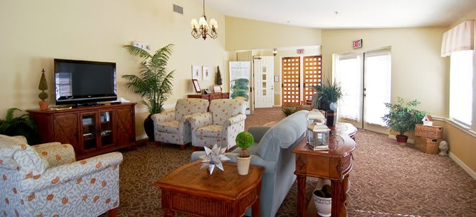 A cozy lobby area with comfortable seating, decorative plants, and warm lighting.