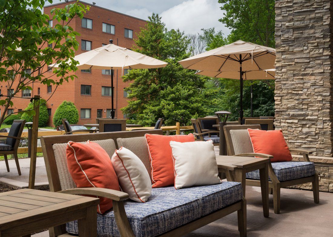 A cozy outdoor patio with cushioned seating and umbrellas, perfect for relaxation.