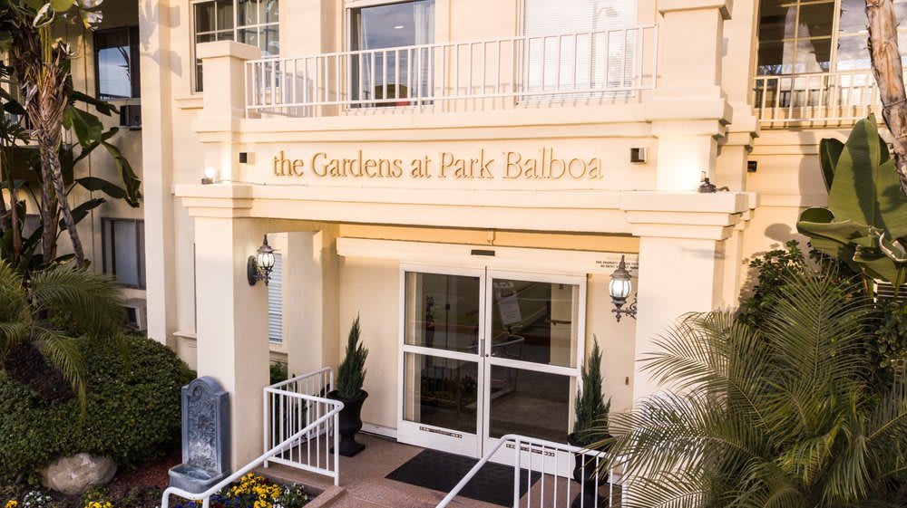 A welcoming entrance to the building with an awning and potted plants.