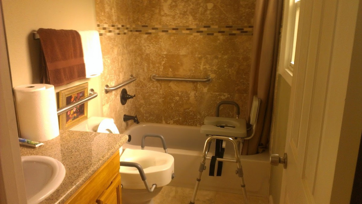 A bathroom equipped with accessibility features, including grab bars and a shower chair.