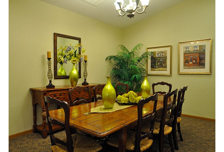 A stylish dining room with a wooden table, elegant chairs, and decorative elements such as a chandelier and artwork.