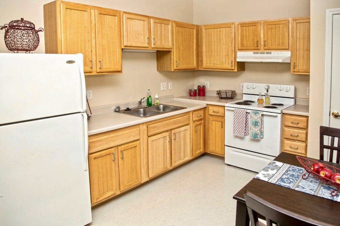 A modern kitchen with wooden cabinets and standard appliances.
