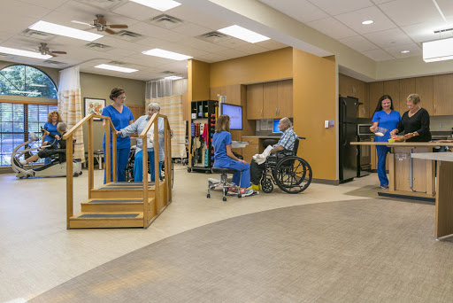A physical therapy session in progress, showcasing medical staff assisting patients in a rehabilitation setting.