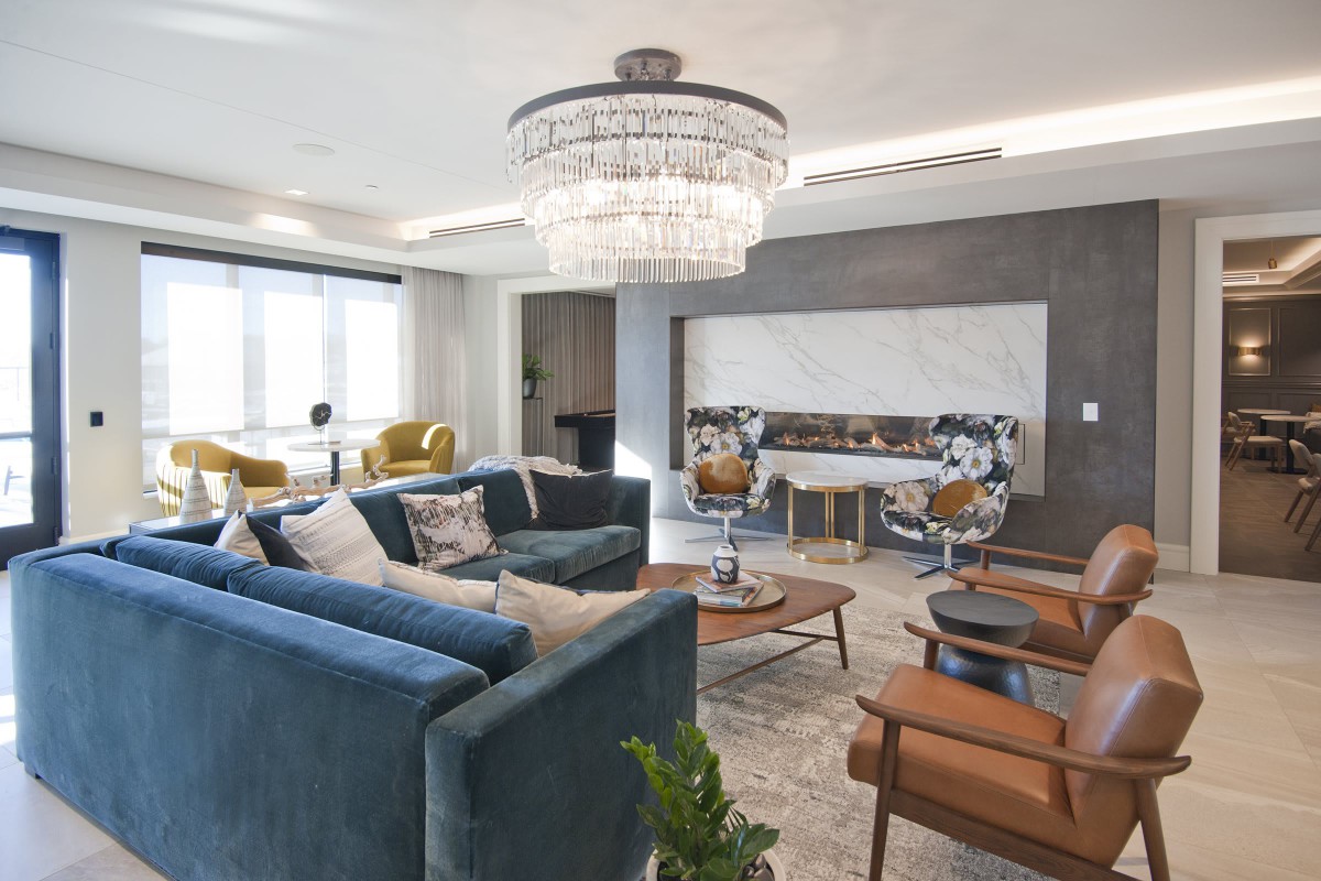 A modern living room with elegant furnishings and a large chandelier.