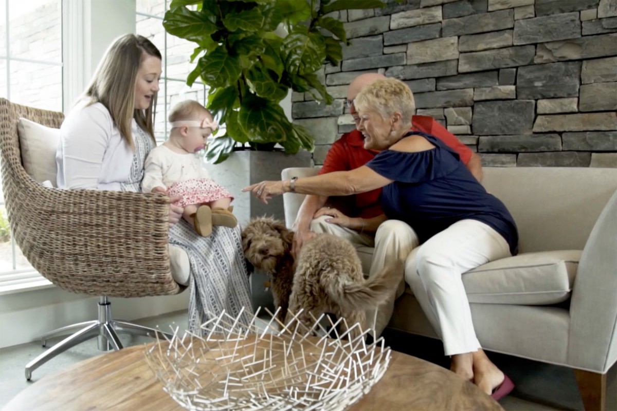 A family sitting together in the living room with their dog.
