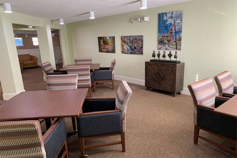A cozy dining area with tables and chairs, decorated with artwork on the walls.