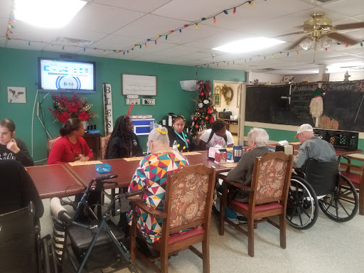 A group of seniors participating in a discussion at a community center, adorned with festive holiday decorations.