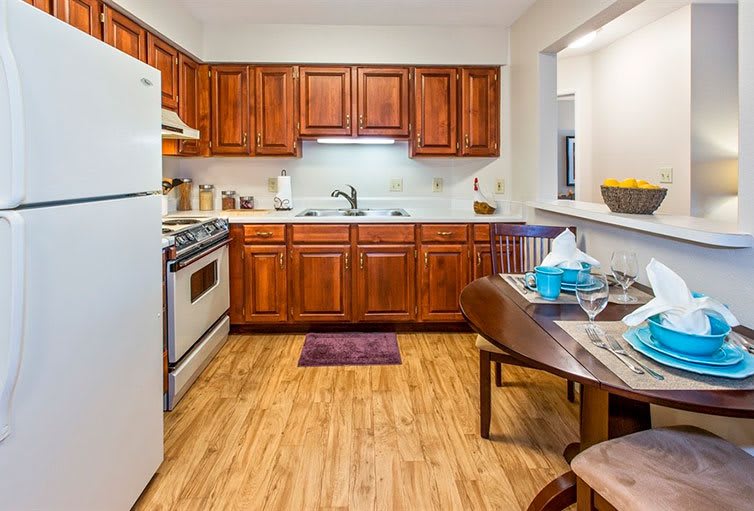 A cozy kitchen with wooden cabinets, a dining area, and modern appliances.