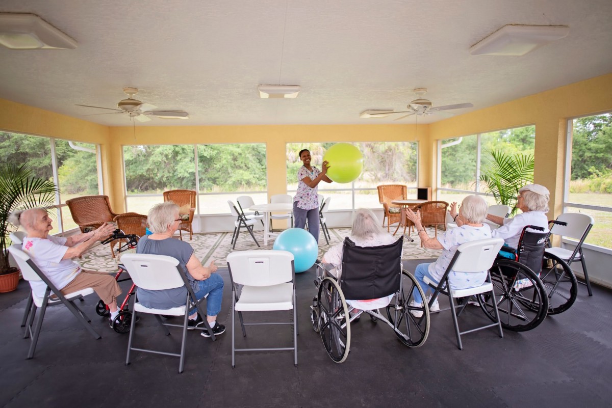 A fitness instructor leads a group of seniors in an exercise class at a community center.