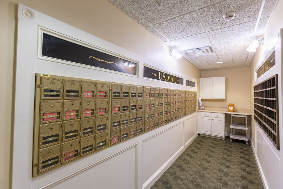 A hallway lined with wall-mounted mailboxes in an office setting.