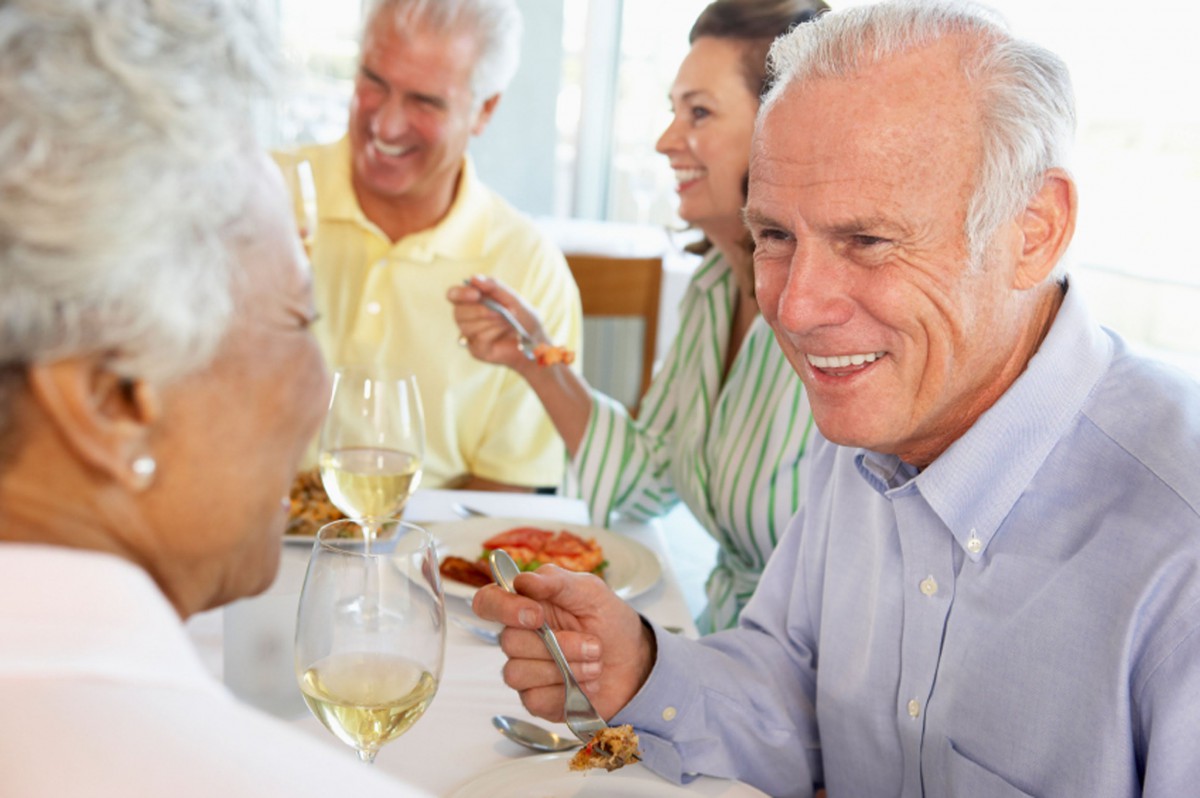 A group of people enjoying a meal and conversation at a restaurant.