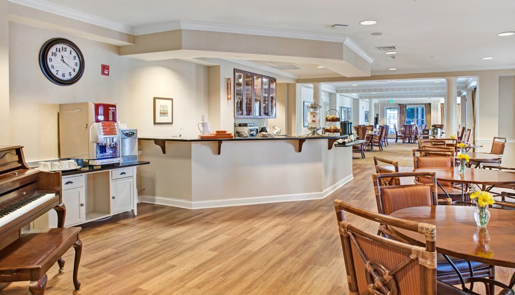 A well-lit reception area with wooden flooring and comfortable seating.