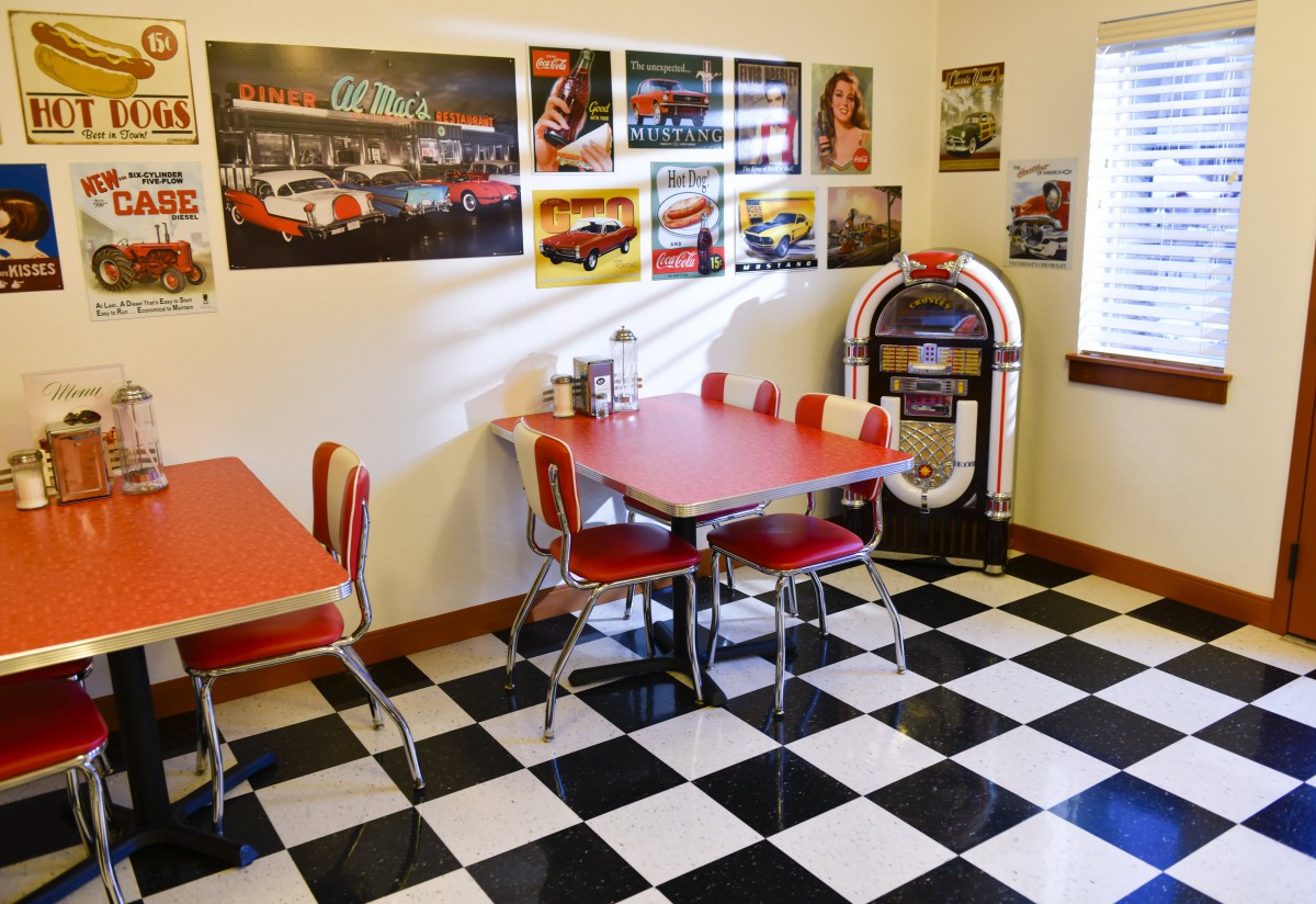 A retro diner with vintage decor, featuring a jukebox and checkered flooring.