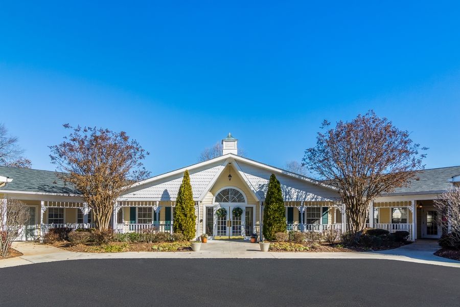 A symmetrical building with a clear blue sky and trees on either side.