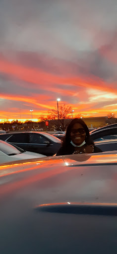 A beautiful sunset casts a vibrant glow over the parking lot, illuminating the scene.