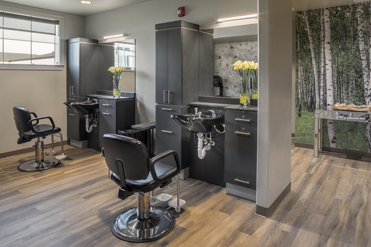 A modern barber shop interior with styling chairs and mirrors.