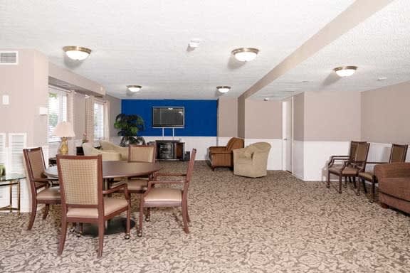 A spacious lounge with multiple seating areas and a television, ideal for meetings or relaxation.
