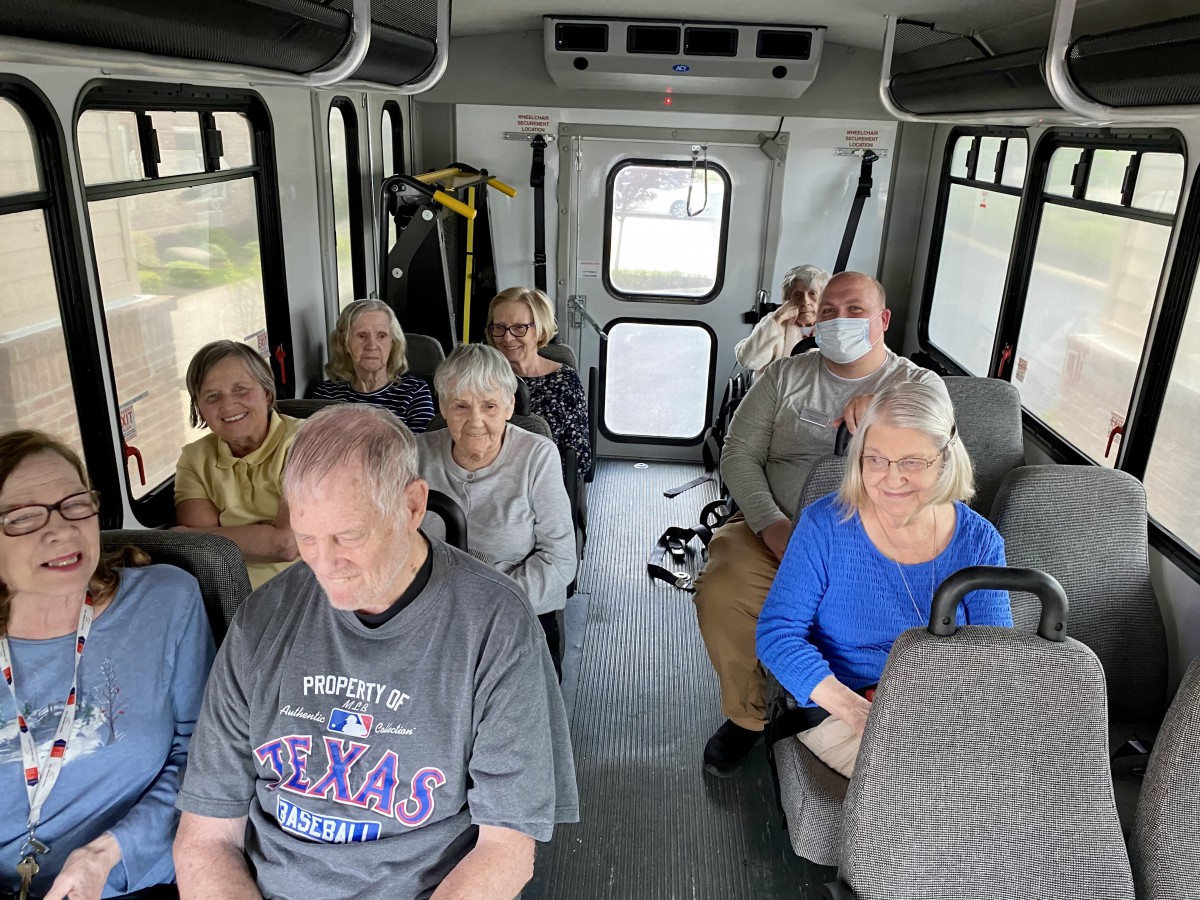 A group of people seated inside a bus, engaged in travel.