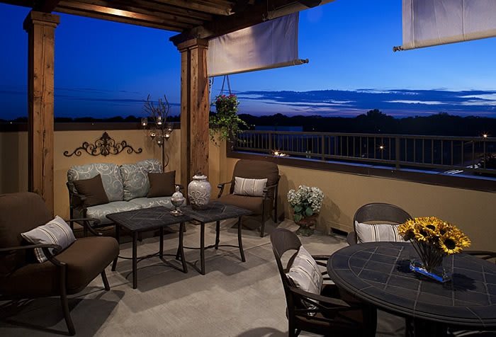 A cozy outdoor patio with comfortable seating and a view of the evening skyline.