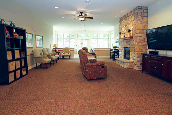A cozy living room with comfortable seating, a fireplace, and large windows.